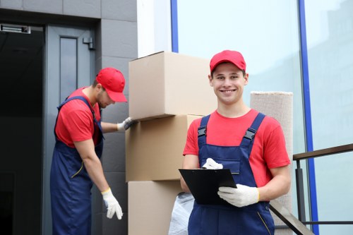 Professional movers handling boxes and furniture in a Holland Park property