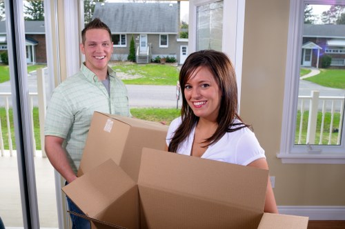 Professional movers handling items carefully in a Holland Park apartment